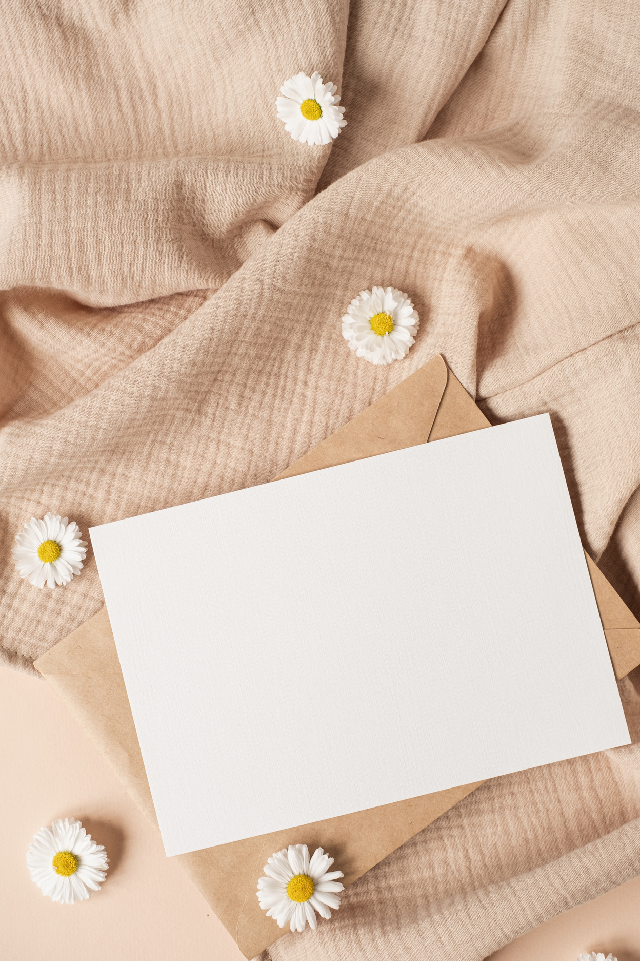 Blank Card with Envelope and Chamomile on Fabric Flatlay